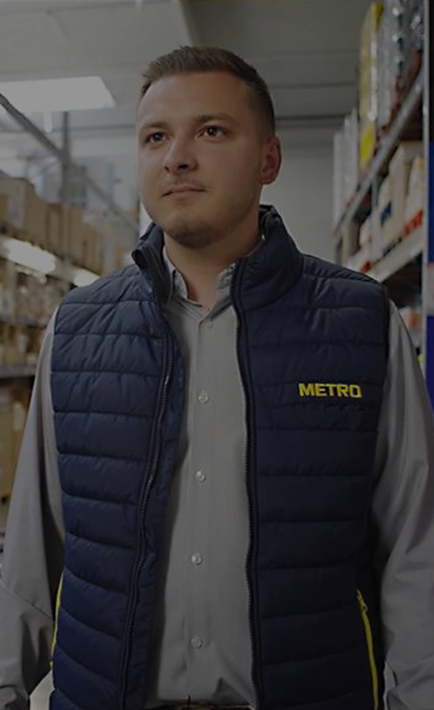 A man wearing a blue vest and a METRO logo.