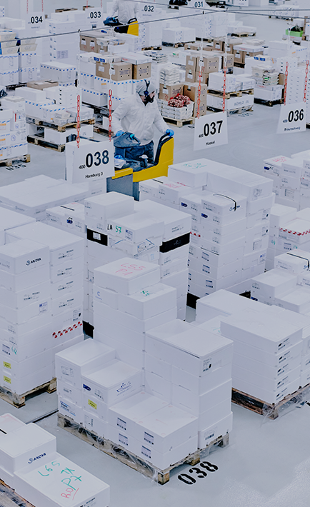 The image shows a warehouse with a large number of boxes stacked on top of each other. 