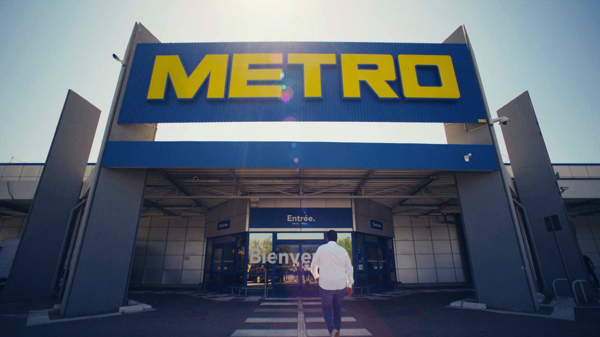 A man is walking towards a METRO store.